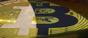 يد تشير إلى رمز بتكوين وبجواره عبارة مرحباً بك اشترِ بتكوين