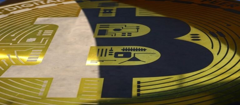 يد تشير إلى رمز بتكوين وبجواره عبارة مرحباً بك اشترِ بتكوين